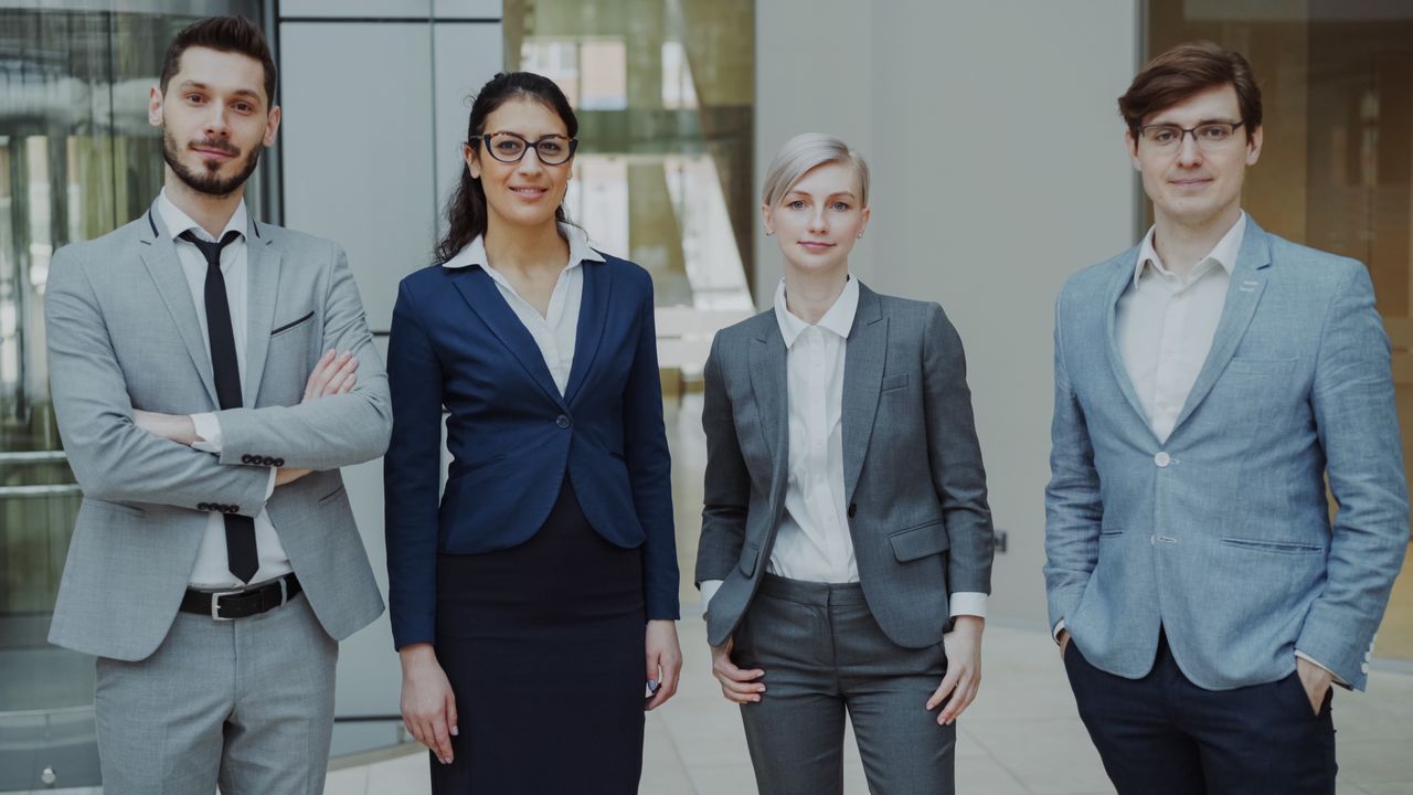 Diverse group of business professionals in an office setting representing corporate teamwork.